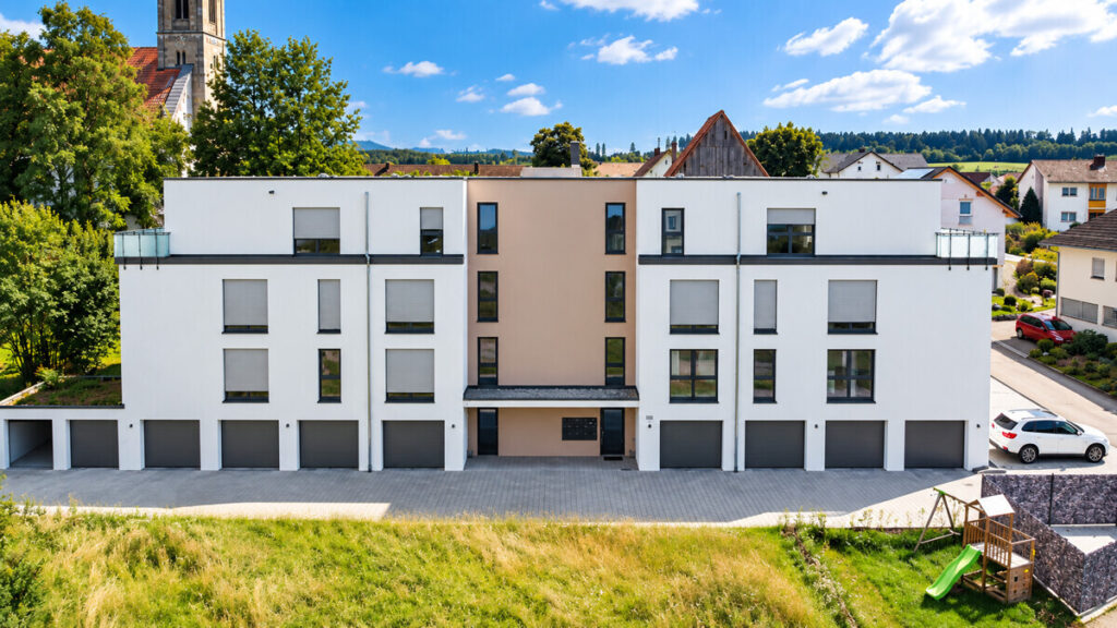 Moderner Wohnbau mit Kirche und Spielplatz